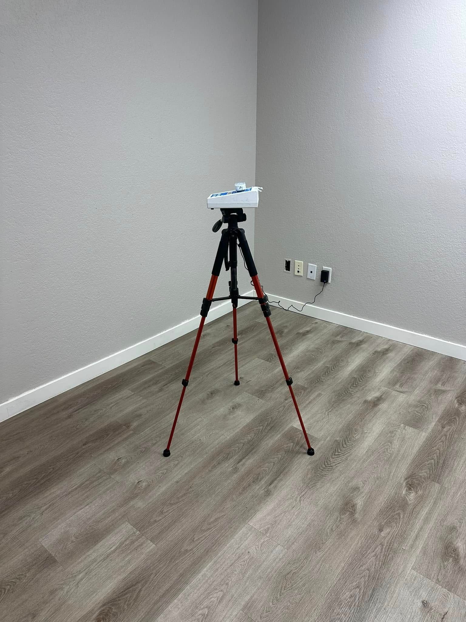 A tripod is sitting in the corner of a room.