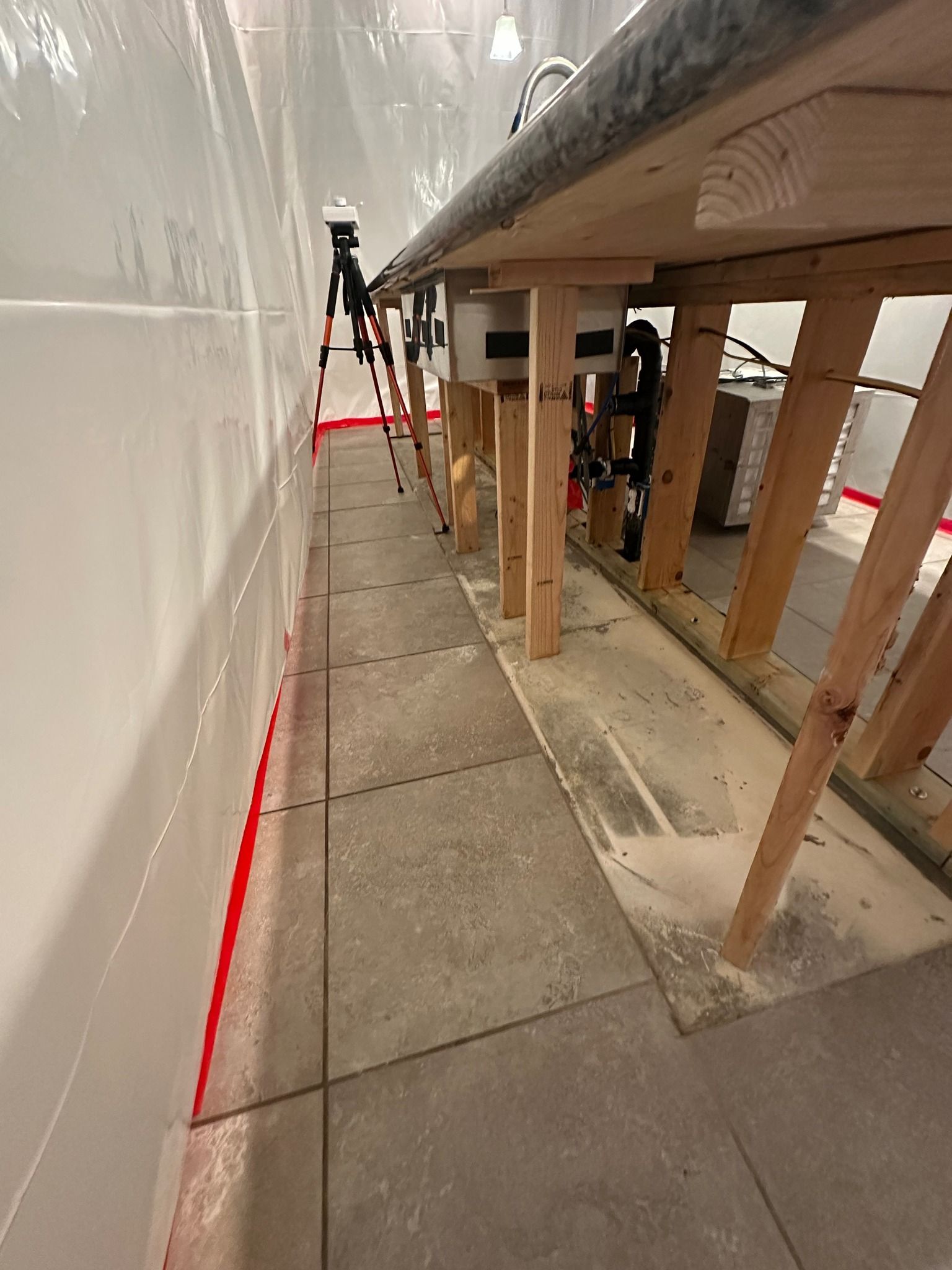 A wooden table is sitting in a room under construction.