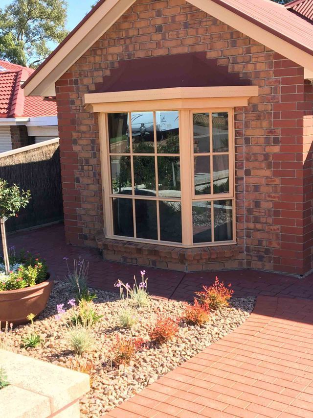 A Brick House With A Large Window And A Red Roof – Adelaide, SA - Sola Bloc Window Tinting