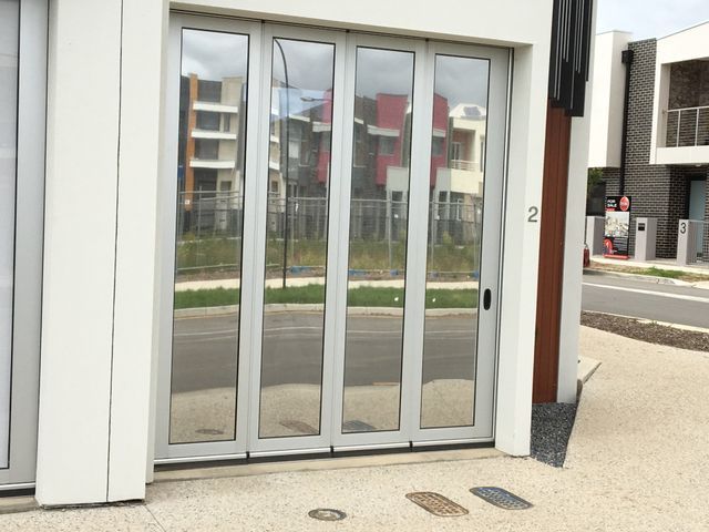A White Building With A Reflection Of A Building In The Windows – Adelaide, SA - Sola Bloc Window Tinting