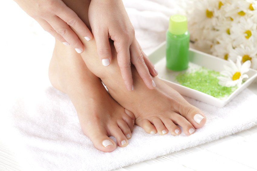 Perfect hands on female feet isolated on white background