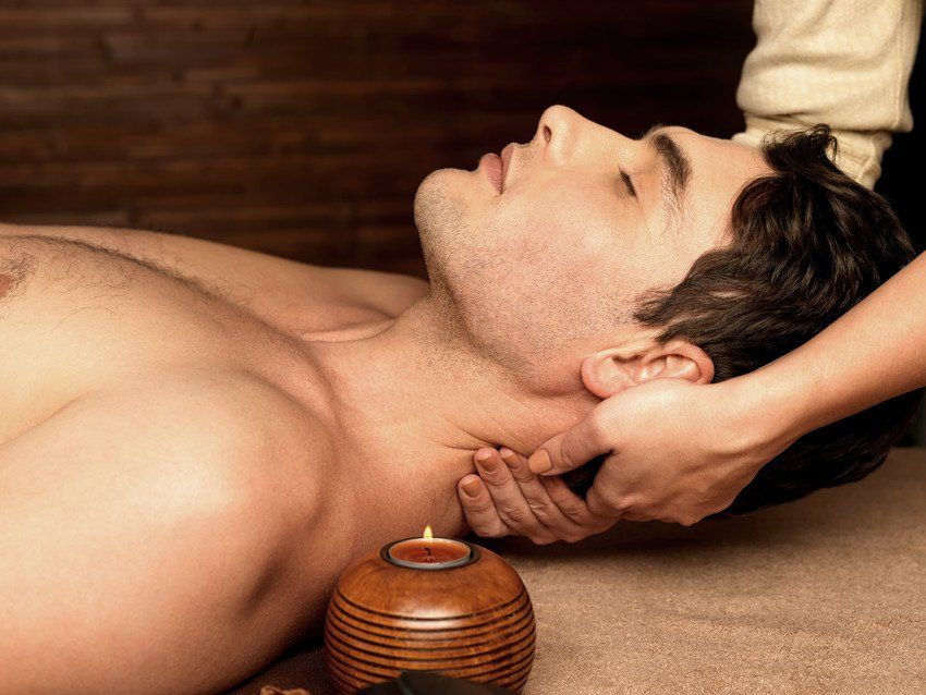 Masseur doing neck massage on man in the spa salon