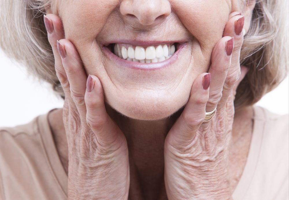 Happy Patient Checking Whitening Results Looking In A Mirror — Dental Prosthetist In Gordon Park, QLD