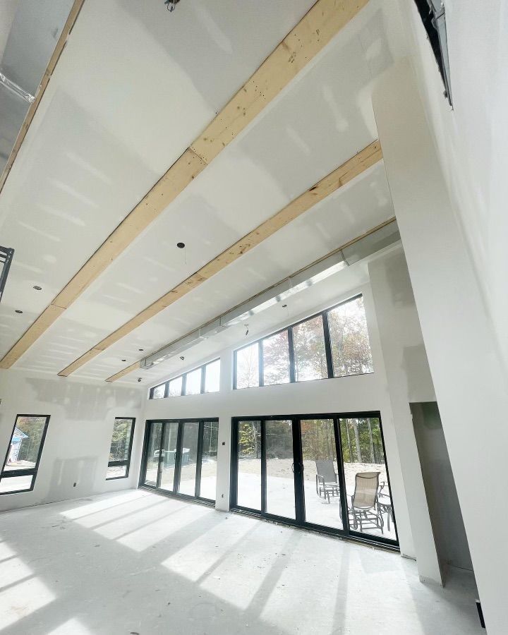 Une grande pièce avec beaucoup de fenêtres et un plafond en bois