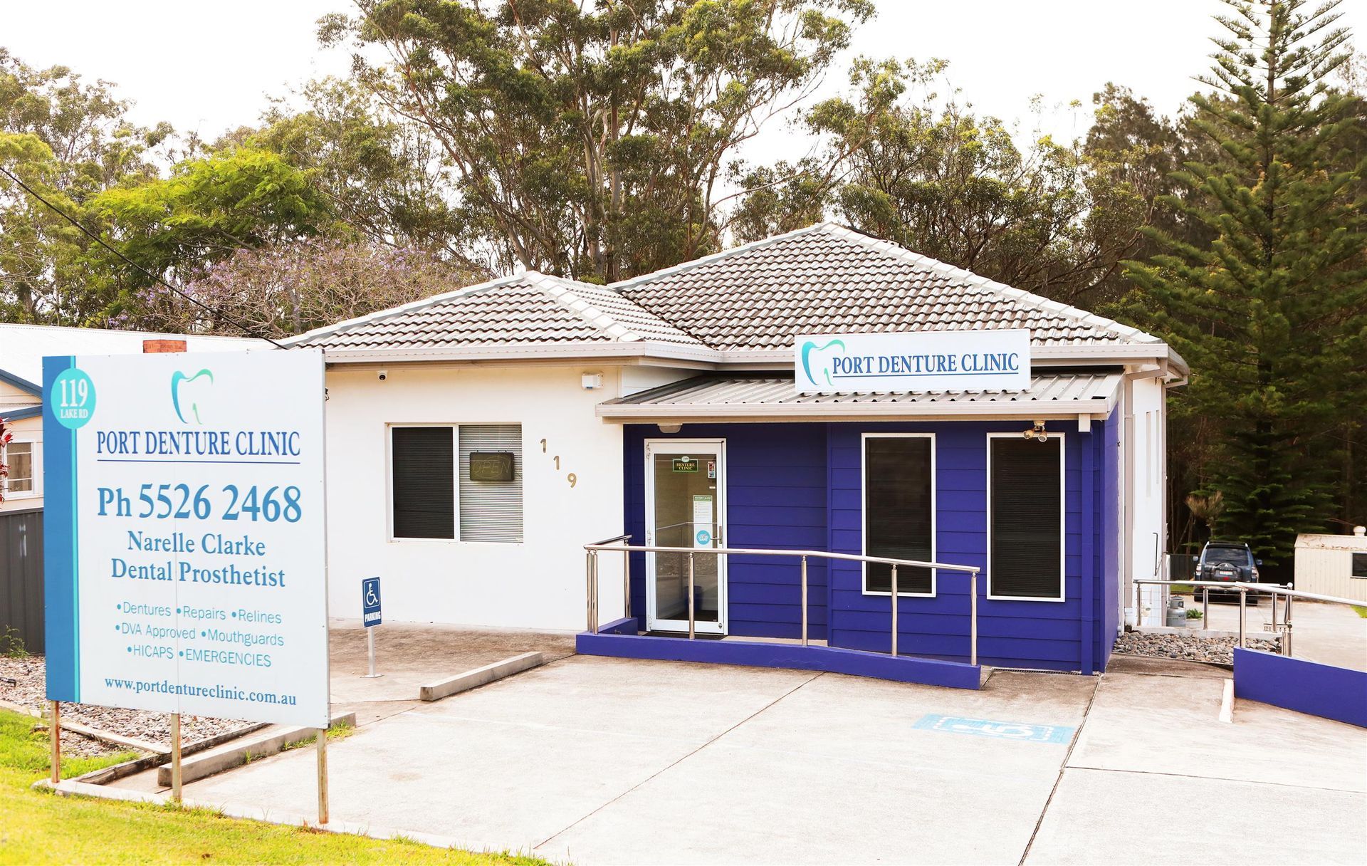 A dentist is talking to an older man in a dental office.