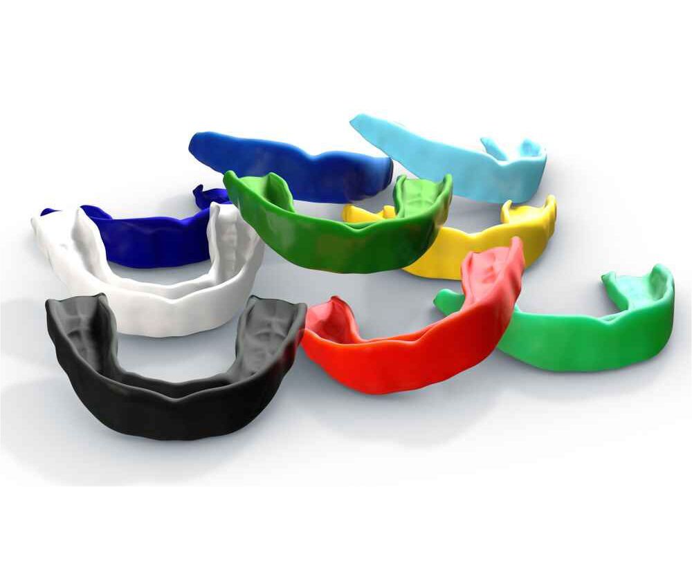 A Bunch of Mouth Guards of Different Colors on A White Surface — Port Denture Clinic In Port Macquarie, NSW