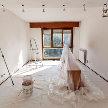 Nkomo Painting & Contracting | An empty room with a bucket of paint and a ladder