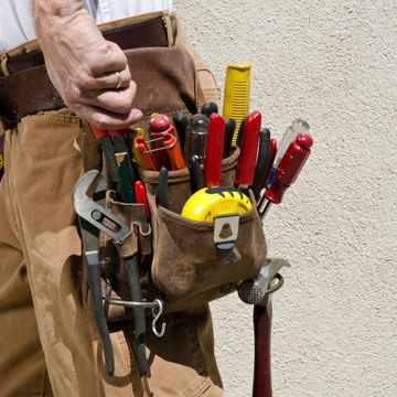 Nkomo Painting & Contracting | A man is wearing a tool belt filled with tools