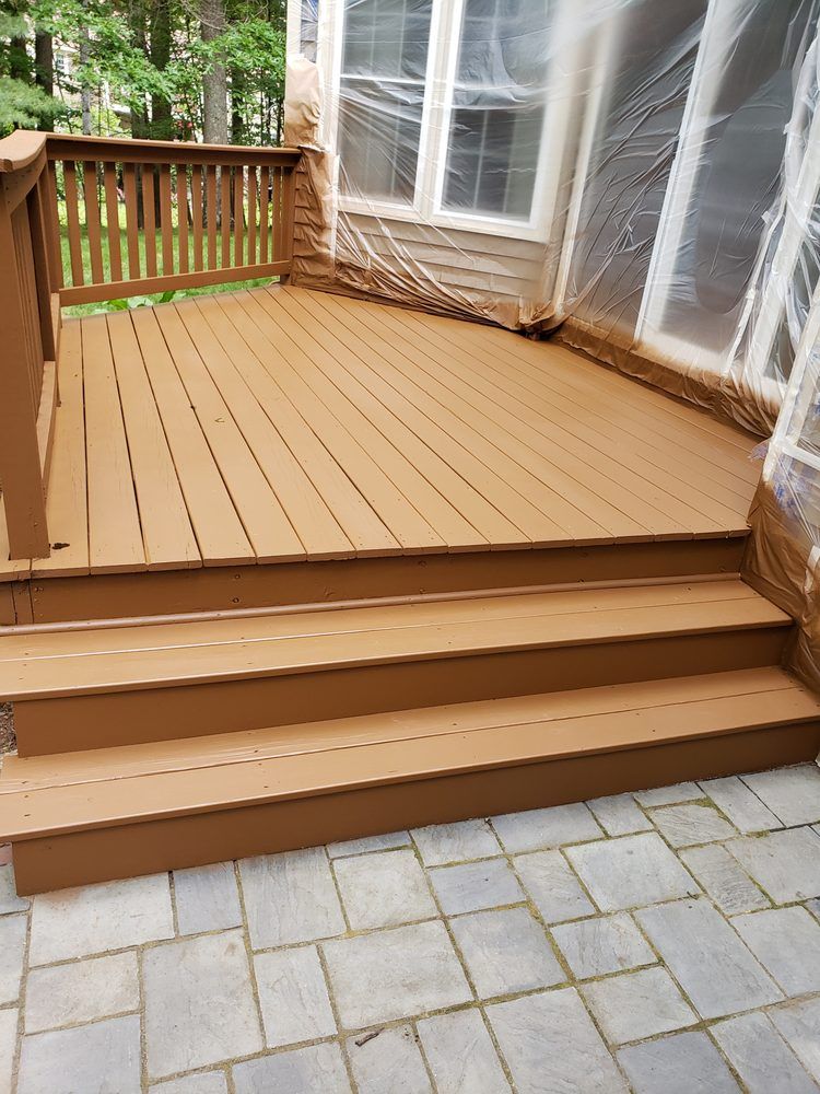 Nkomo Painting & Contracting | A wooden deck with stairs and a railing is covered in plastic.