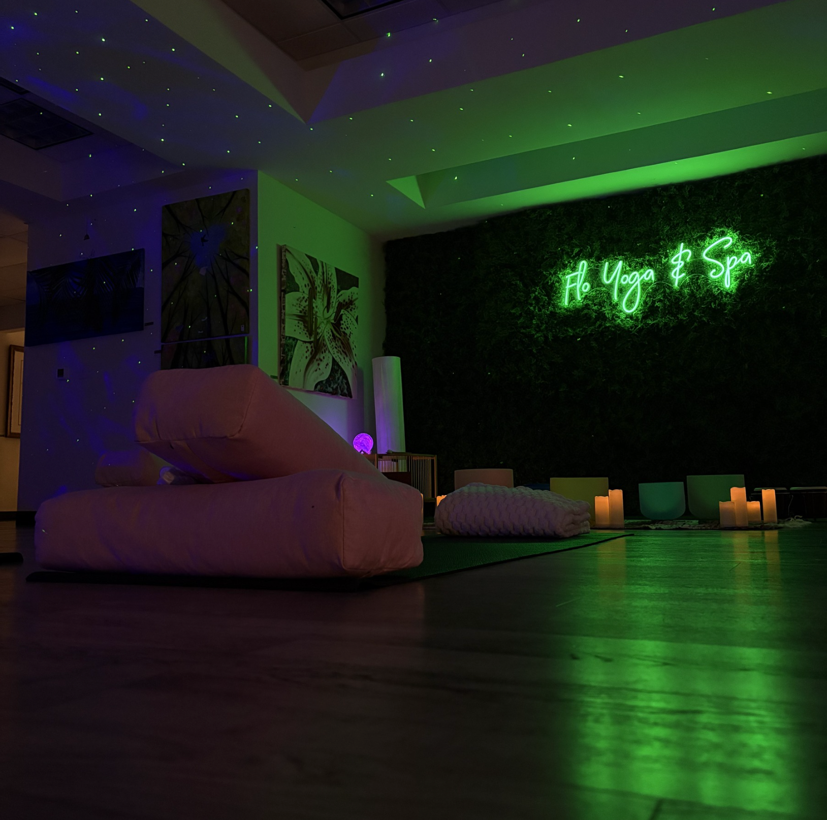 A living room with a green neon sign on the wall