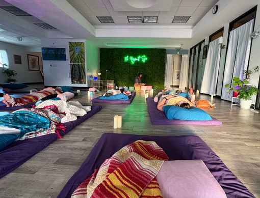A group of people are laying on purple mats in a room