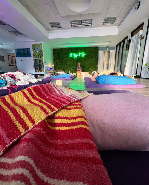 A group of people are laying on yoga mats in a room.