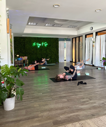A group of people are laying on yoga mats in a room.