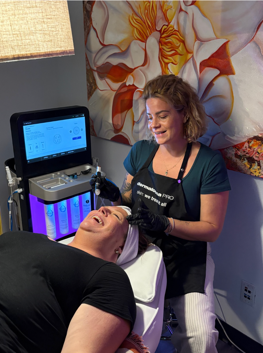 A woman is giving a woman a facial treatment in a salon.