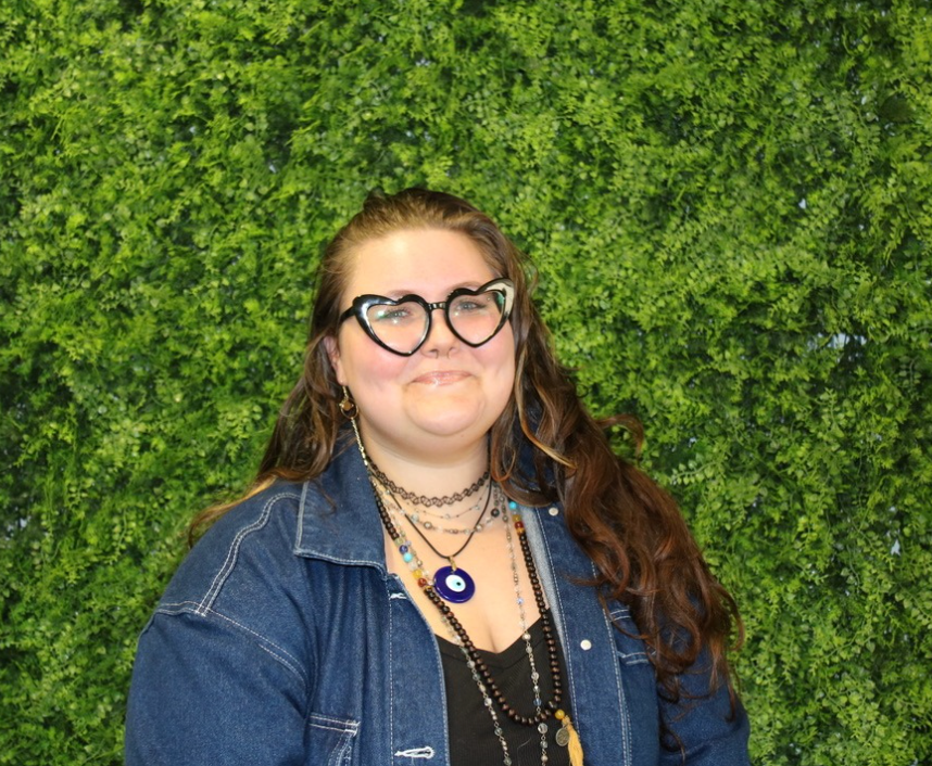 A woman is wearing headphones in front of a wall that says live on air