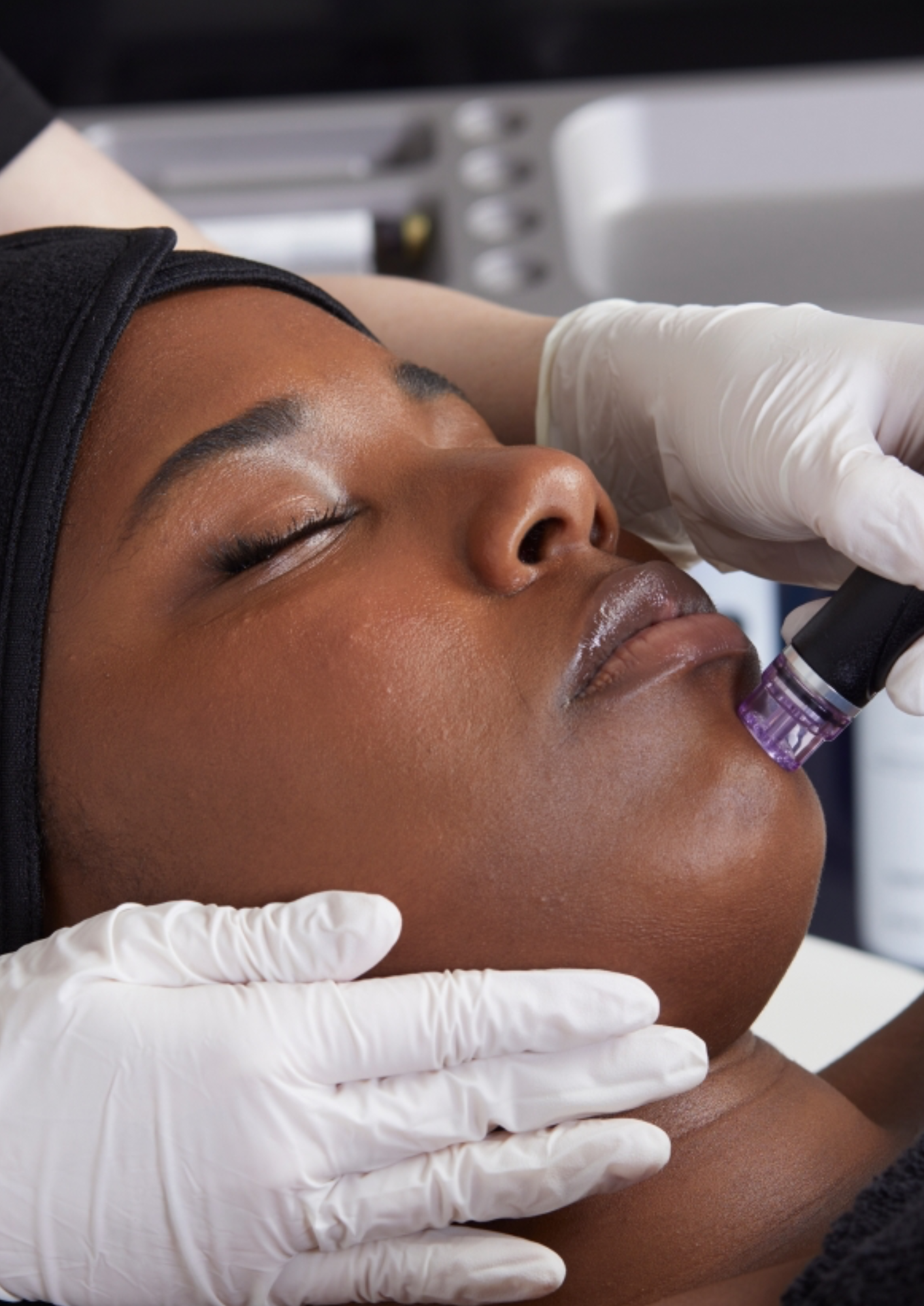 A woman is getting a treatment on her face.