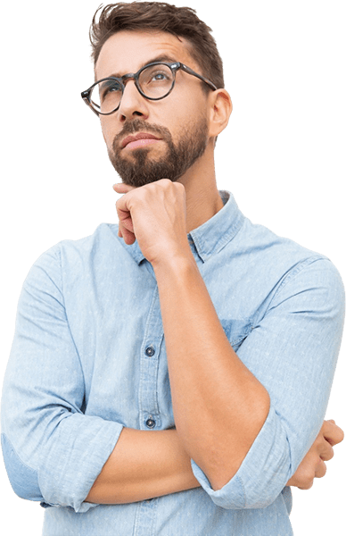 Hombre con gafas, barba, camisa azul, mirando hacia arriba, expresión pensativa, mano en la barbilla.