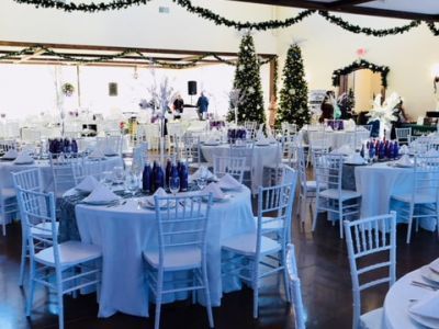 A large room with tables and chairs set up for a wedding reception.