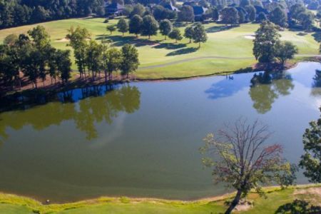An aerial view of a golf course with a lake in the middle
