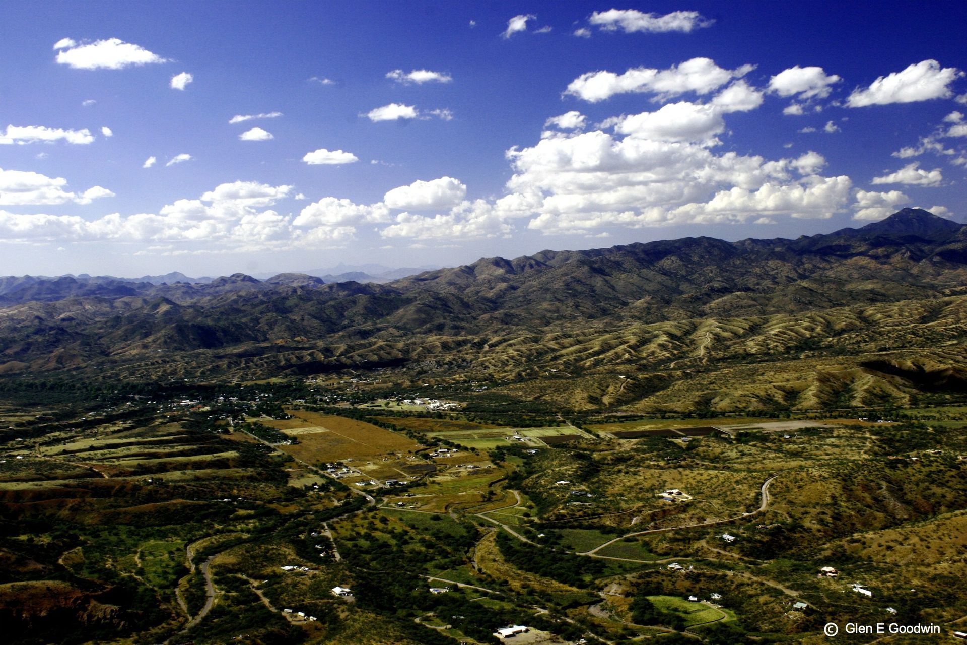 An aerial view of a valley with mountains in the background