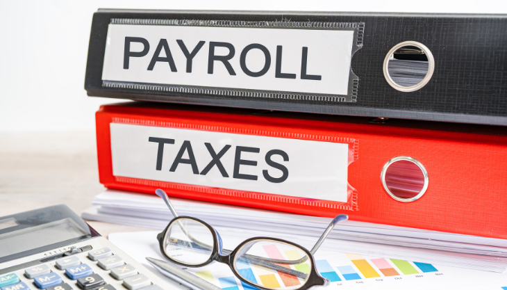 Stacks of payroll tax management paperwork on an office table