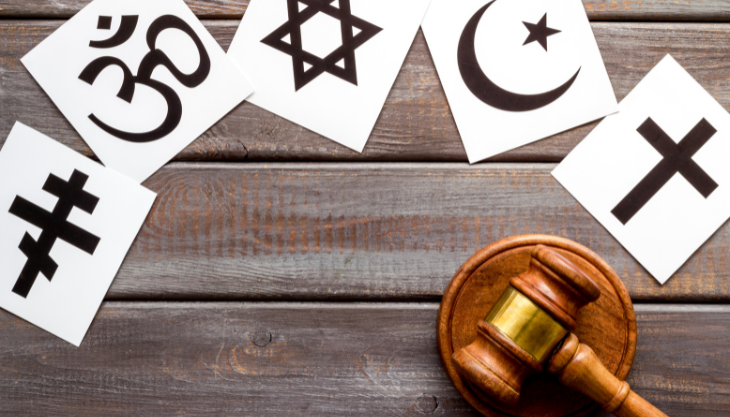 a judge's gavel surrounded by religious symbols after a religious accommodation policy decision