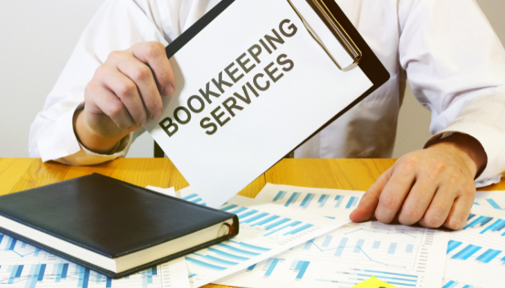 Professional man holds a clipboard for outsourced bookkeeping services