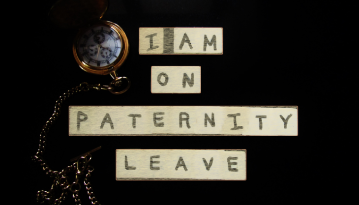 Handwritten sign with standard paternity leave statement
