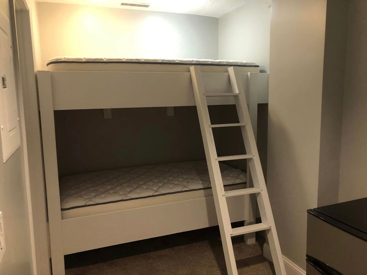 A bunk bed with a ladder in a small room.
