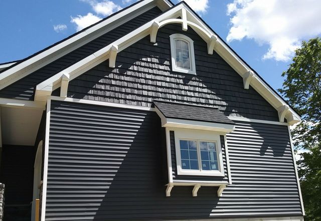 A black house with a white trim and a window