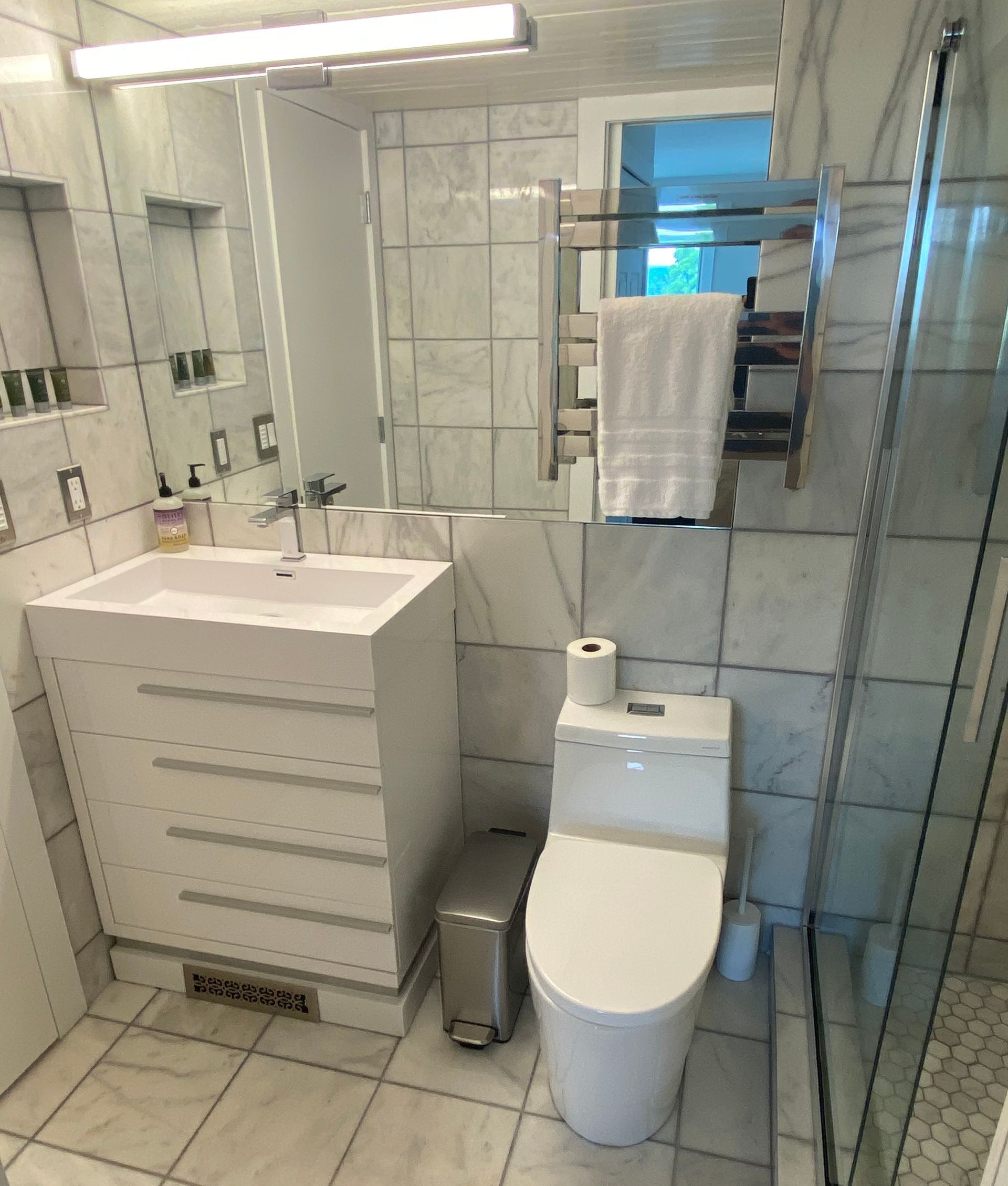 A bathroom with a toilet a sink and a mirror