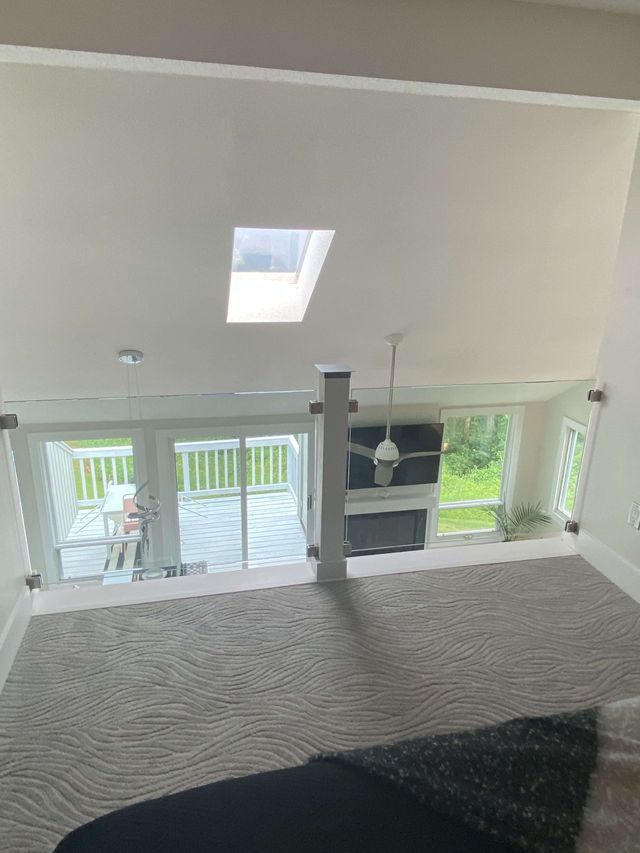 A living room with a skylight and a ceiling fan.