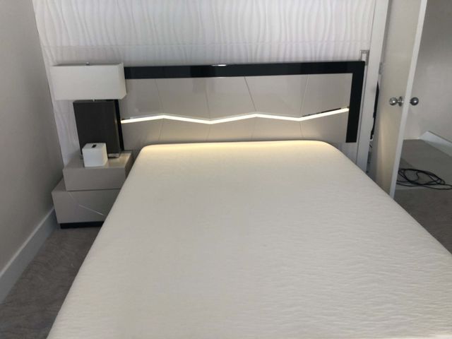 A bedroom with a bed , nightstand and lamp