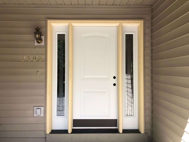 A white door with a light on the side of it