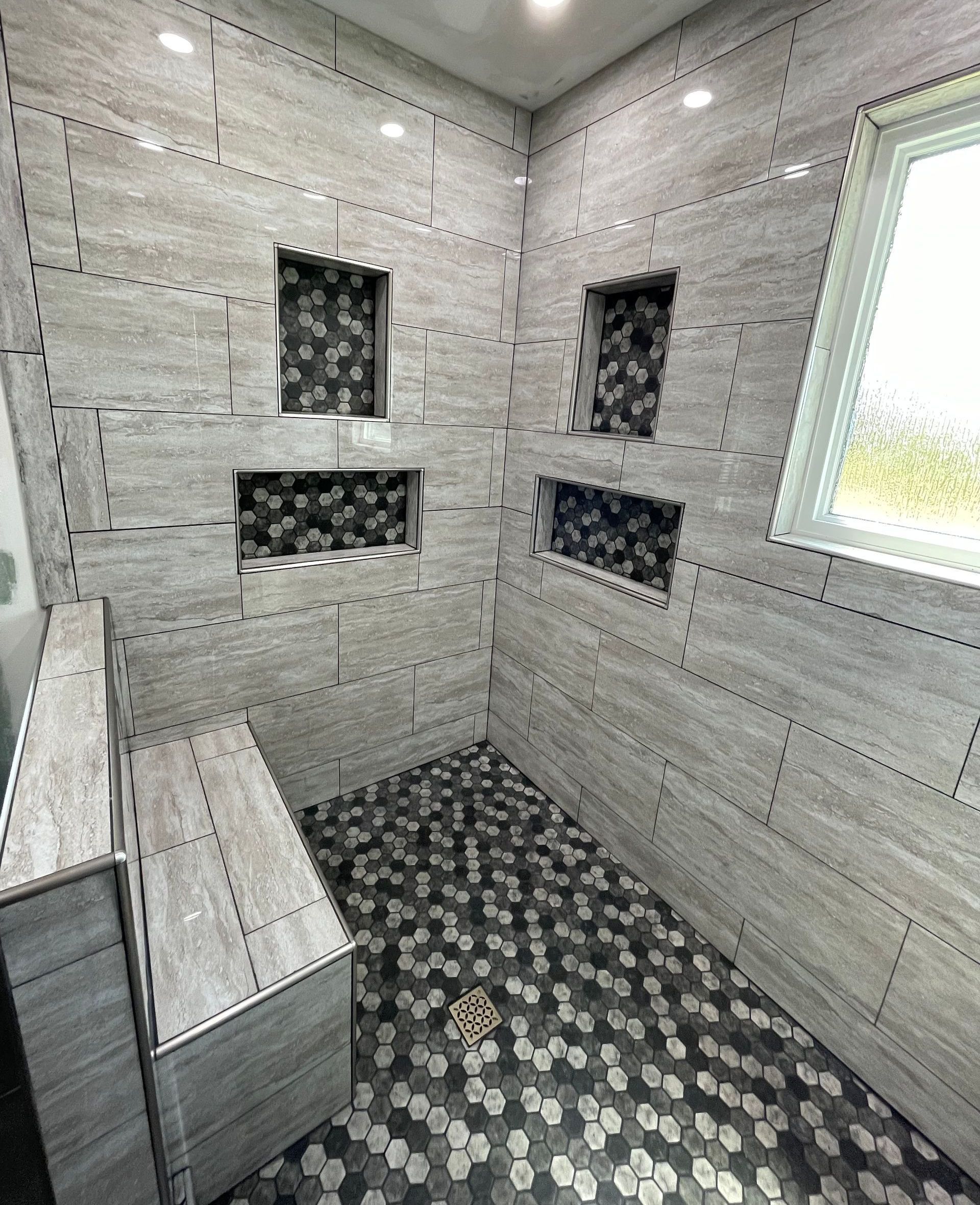 A bathroom with a walk in shower and a window.