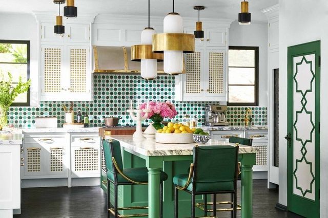 A kitchen with green cabinets , green chairs , and a green island.