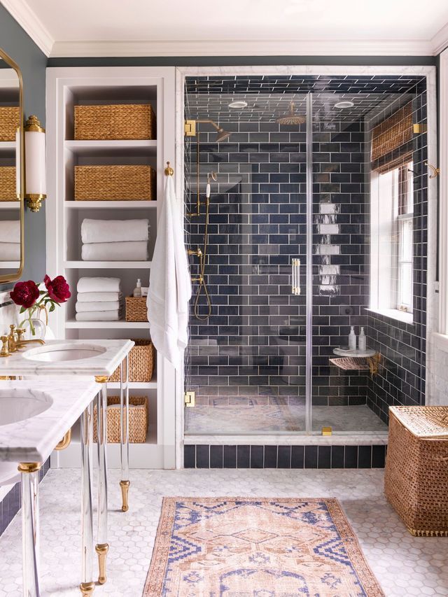 A bathroom with a walk in shower , sink , and rug.