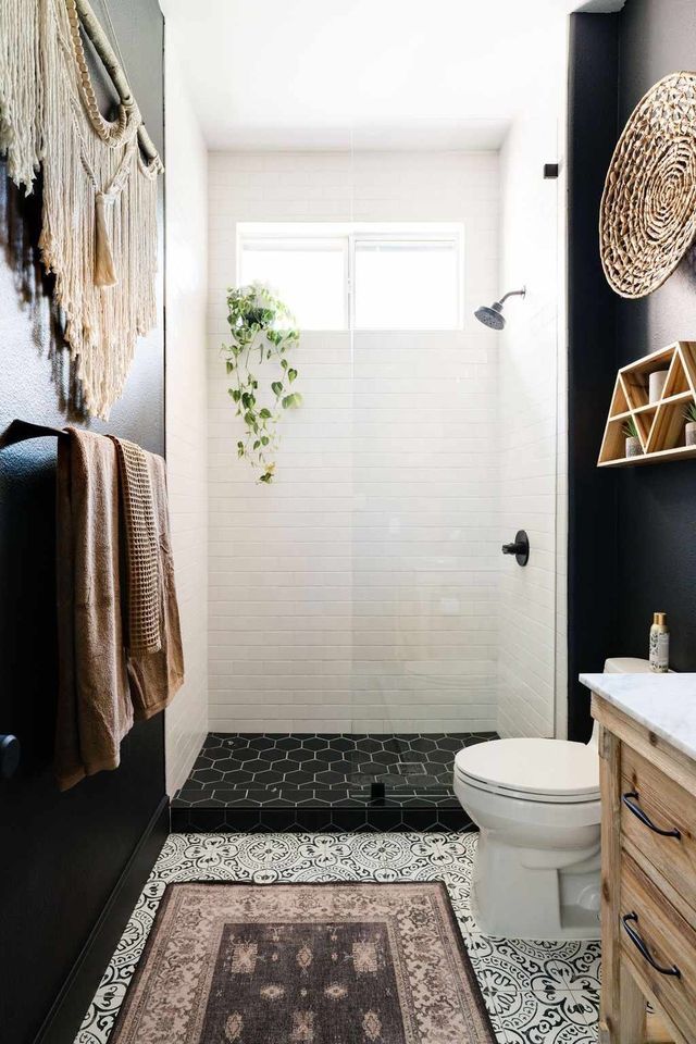 A bathroom with a toilet , sink , shower and rug.