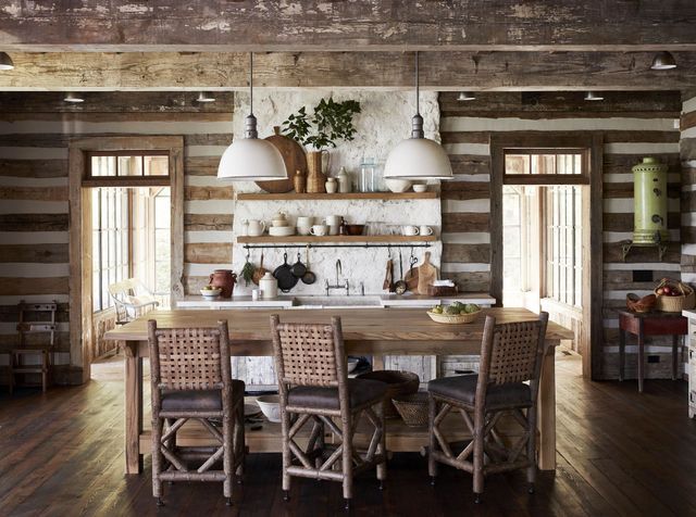 A kitchen in a log cabin with a table and chairs