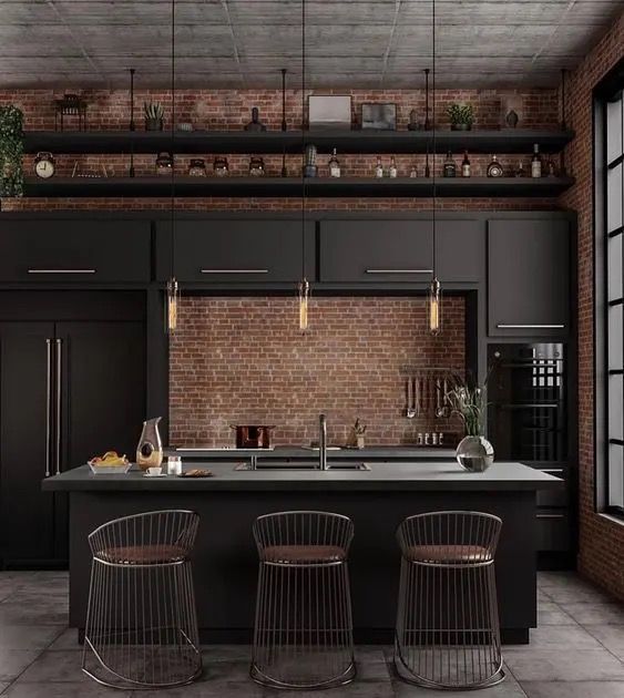 A kitchen with black cabinets and a brick wall.