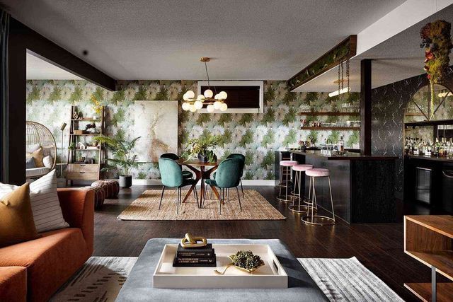 A living room with a couch , table , chairs and a rug.