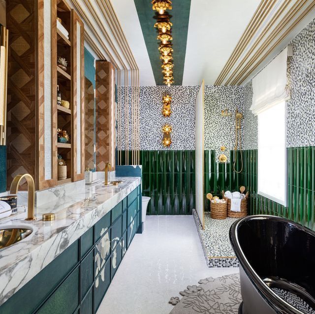 A bathroom with green tiles and a black tub