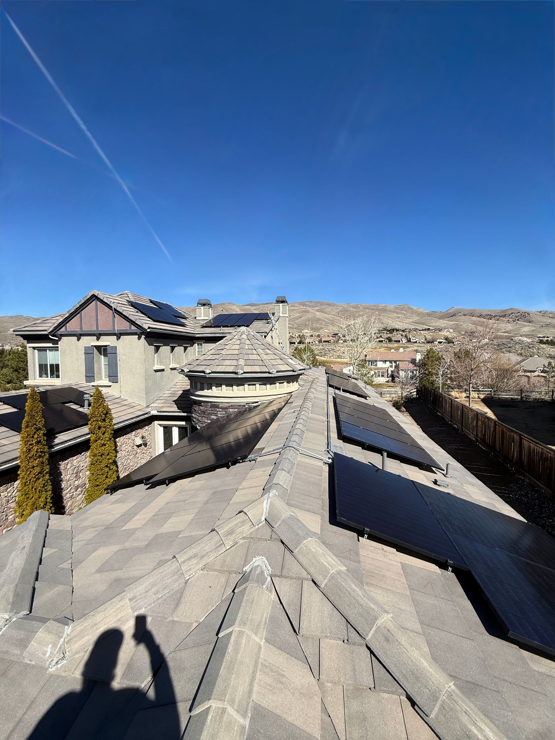 There are many solar panels on the roof of a building.