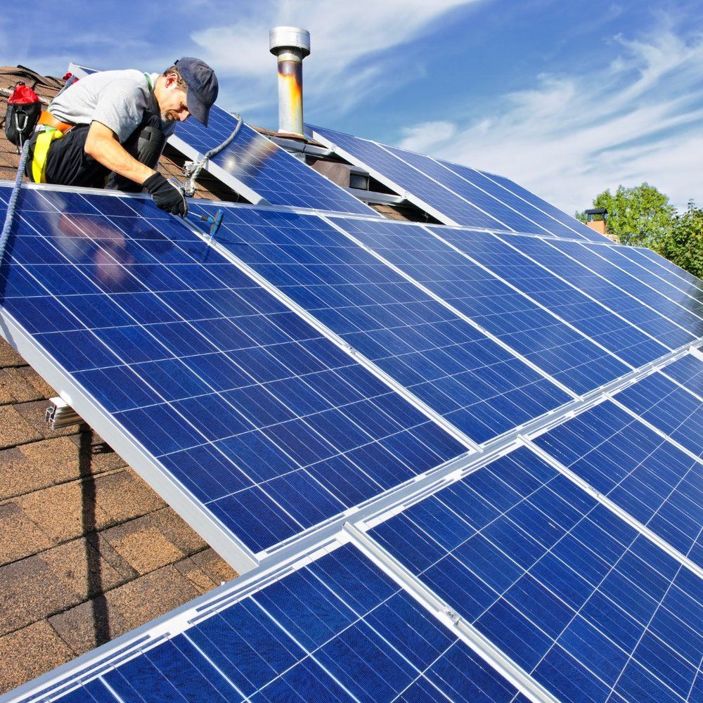 A man is installing solar panels on a roof