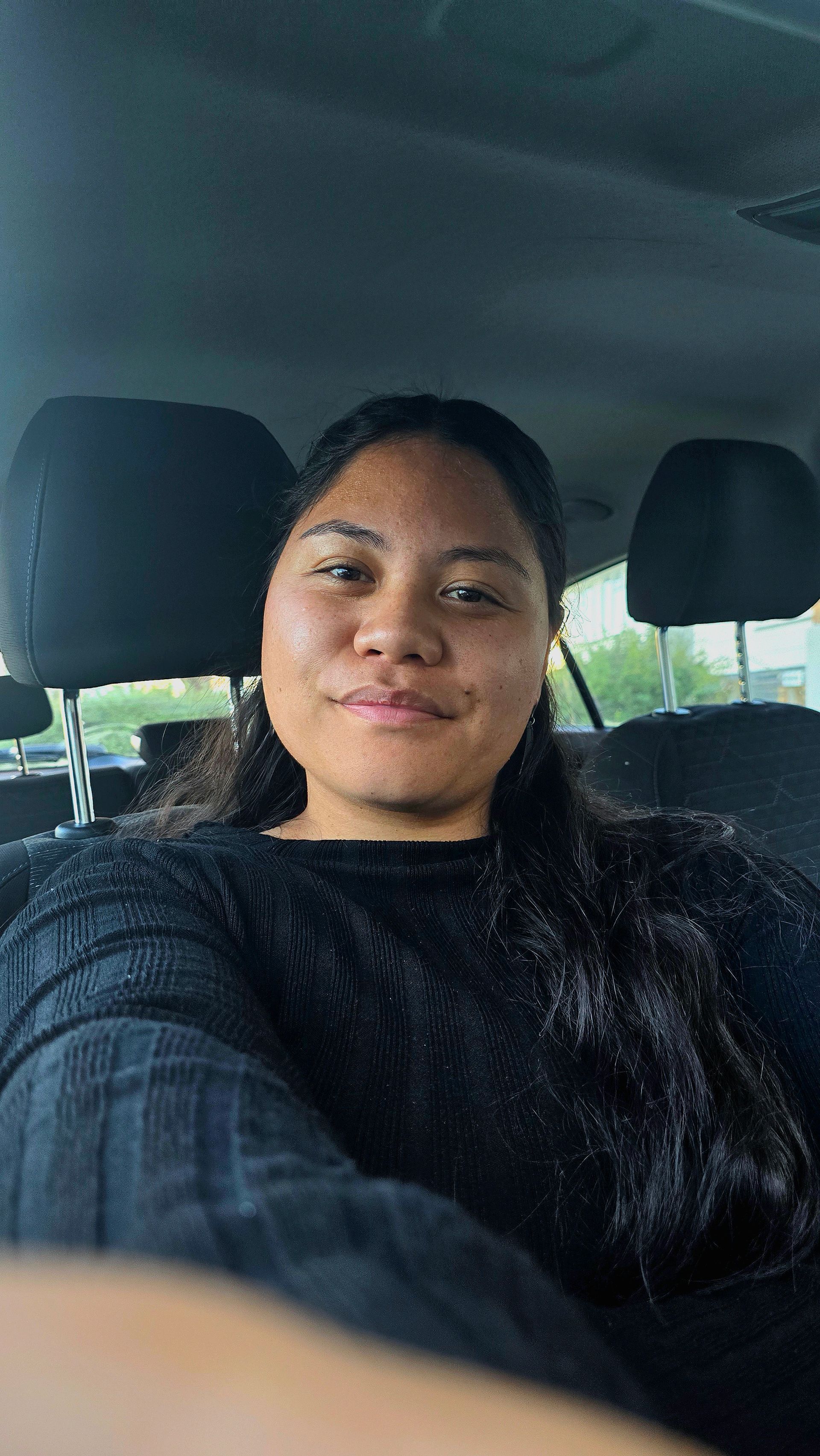 A woman wearing a white shirt and a green necklace