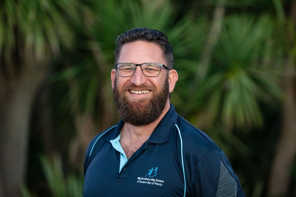 A man with a beard and glasses is smiling for the camera.