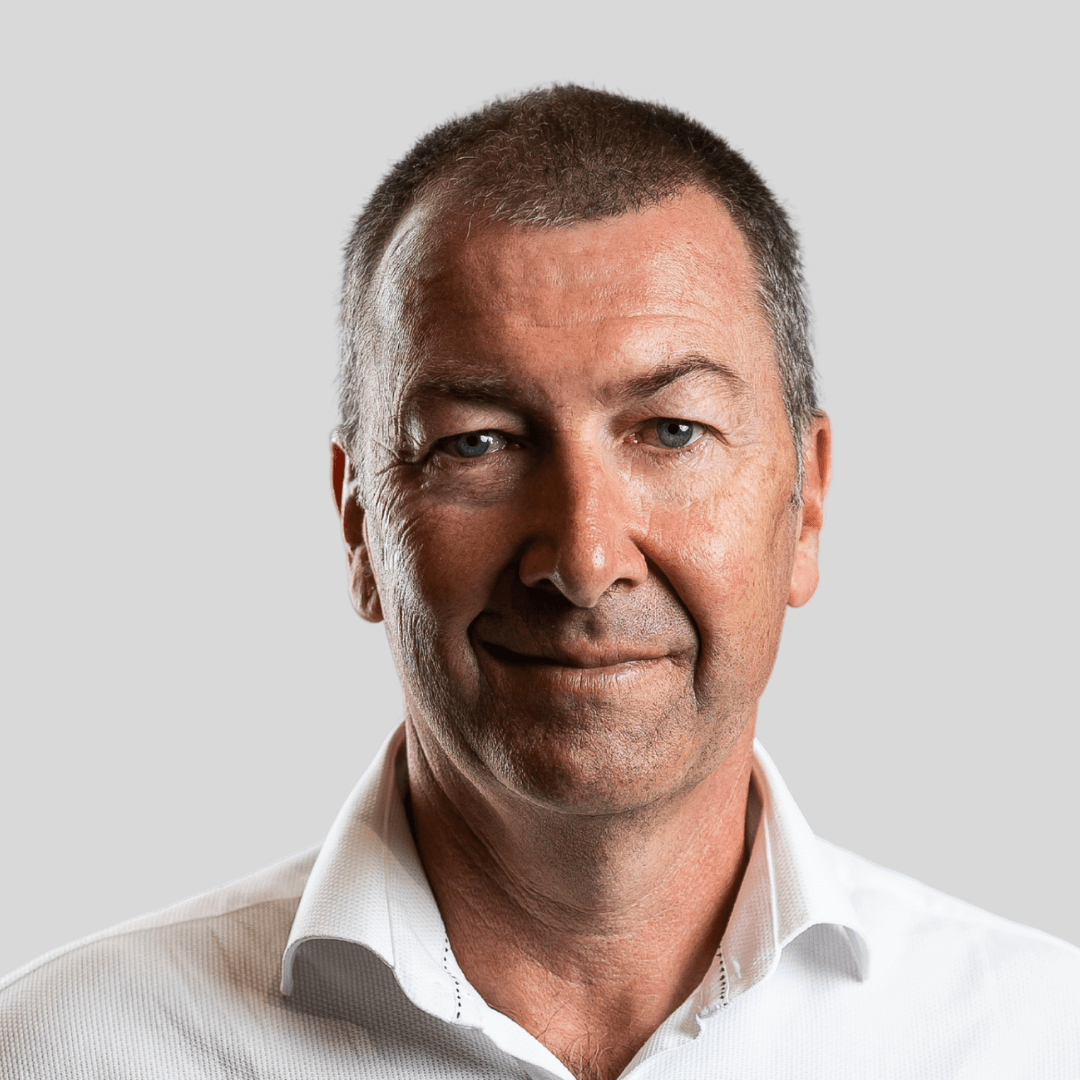 A man in a white shirt is smiling for the camera.