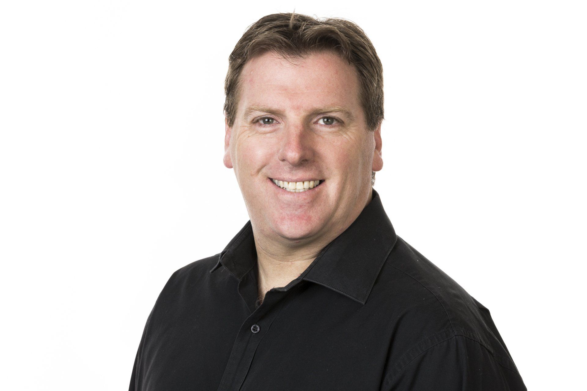 A man in a black shirt is smiling for the camera.