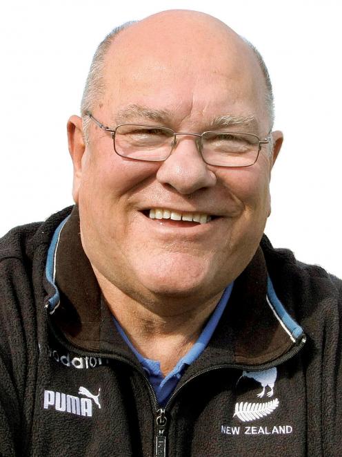 A man wearing glasses and a puma jacket smiles for the camera