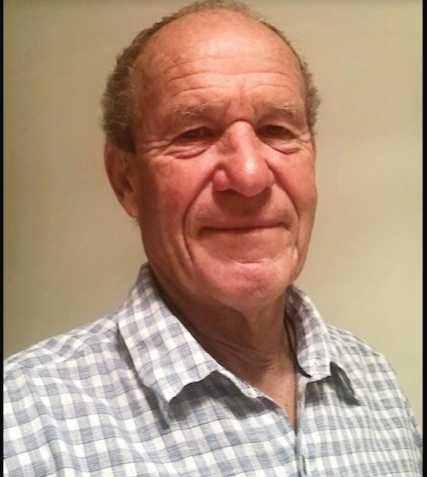 A man in a plaid shirt is smiling for the camera.